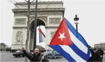  ?? Foto: AFP/Dominique Faget ?? Triumph am Bogen: Kubaner zeigen in Paris Flagge.