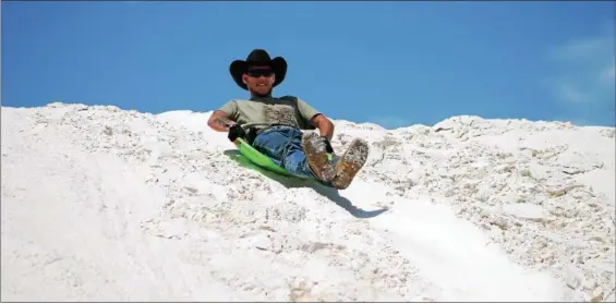  ?? KRISTI GARABRANDT — THE NEWS-HERALD ?? Matthew Bates of Canton coasts down a sand dune on a disc sled at White Sands National Monument in the northern Chihuahuan Desert in New Mexico, where sand sledding is a popular activity.