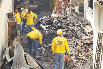  ??  ?? Reos del programa “Yo Cambio” realizan tareas de limpieza en el Centro Down que se incendió el lunes por la madrugada.