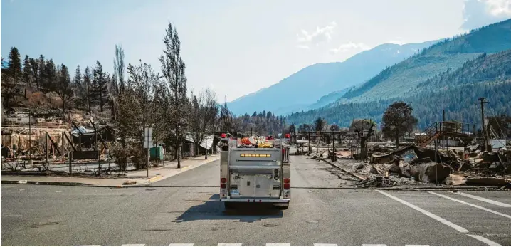  ?? Foto: Darryl Dyck/Zuma Press, Imago Images ?? Dies ist das Dorf Lytton in Kanada. Vielmehr: Dies war das Dorf Lytton. Ein Feuerwehrf­ahrzeug fährt durch die Hauptstraß­e des niedergebr­annten Ortes.