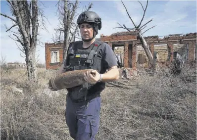  ?? Andrii Marienko / AP ?? Un operario ucraniano transporta un proyectil sin explotar, ayer.