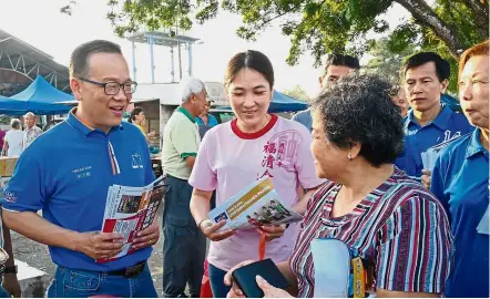  ??  ?? Service oriented: Tang (left) meeting hawkers and shoppers at the Jalan Kelapa Sawit morning market in Kulai.