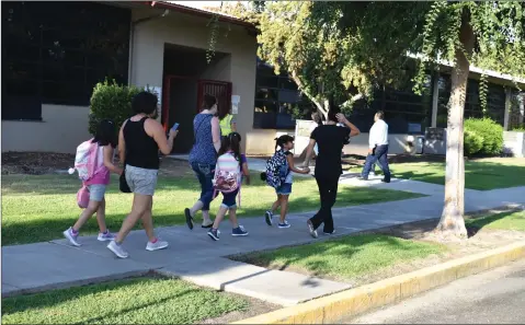  ?? RECORDER PHOTO BY JAMIE A. HUNT ?? Children walk with their parents to school on the first day back after summer break on Thursday, August 8.