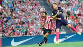  ?? — AP ?? Ivan Rakitic (right) of Barcelona heads the ball into the goal as Mikel Balenziaga of Athletic Bilbao tries to challenge him on Sunday. Barcelona won 1-0.