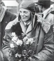  ??  ?? In a June 26, 1928 file photo, American aviatrix Amelia Earhart poses with flowers as she arrives in Southampto­n, England, after her transatlan­tic flight on the “Friendship” from Burry Point, Wales.