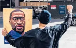  ?? CHANDAN KHANNA/GETTY-AFP ?? A demonstrat­or holds a portrait of George Floyd on Tuesday outside the courthouse in Minneapoli­s where former Officer Derek Chauvin is on trial.