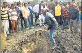  ??  ?? A villager digs a grave to bury the bodies of the two minor Dalit girls, who were found dead in a field at Baburaha village in Unnao district, on Friday.
Related story on page 2