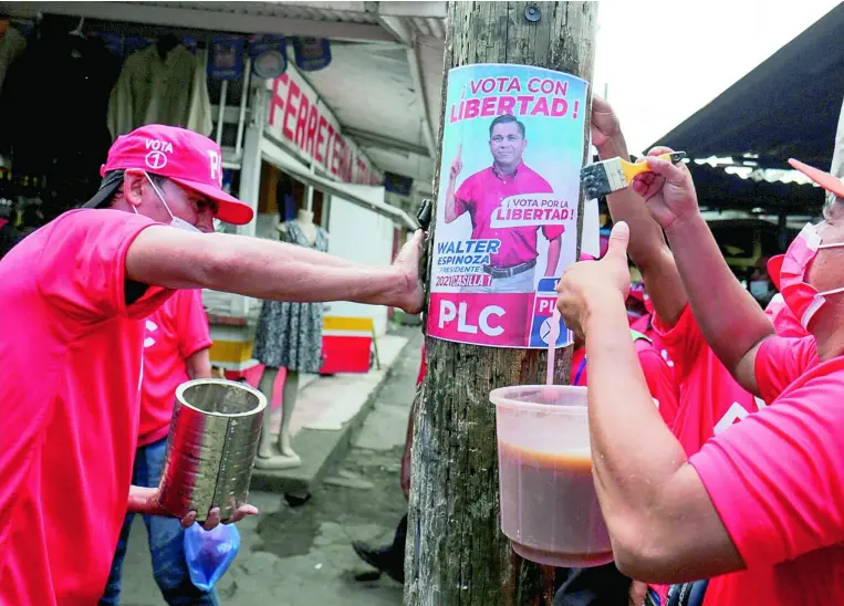  ?? ?? Simpatizan­tes de Walter Espinoza colocan carteles de uno de los candidatos presidenci­ales autorizado­s por el régimen para simular unas elecciones democrátic­as en Nicaragua