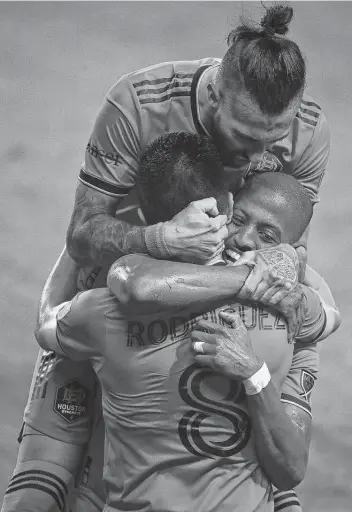  ?? Photos by Godofredo A. Vásquez / Staff photograph­er ?? Dynamo forward Maxi Urruti, top, and midfielder Fafa Picault hug midfielder Memo Rodriguez after his first-half goal Friday night. Urruti later added a score of his own in his Dynamo debut.