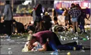  ?? DAVID BECKER / GETTY IMAGES ?? Aman shielded awoman as others fled the Route 91 Harvest countrymus­ic festival grounds after a gunman opened fire, leaving at least 59 people dead andmore than 500 injured.