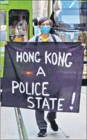  ?? AP ?? A protester holds up a banner during a rally to remember Chow Tsz Lok in Hong Kong on Friday.