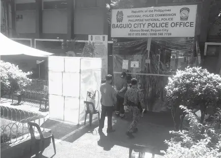  ?? Photo by Jonathan T. Llanes ?? POLICE PRECAUTION. Police and civilians entering the Baguio City Police Office (BCPO) undergo disinfecti­on, thermal scanning and use of foot bath before they are allowed entry at the police office.