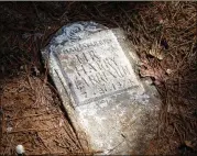  ?? STEVE SCHAEFER FOR THE AJC ?? A marker lies on the ground at Macedonia African Methodist Church Cemetery in Johns Creek last month. Records show the property was originally sold in 1905 to Black residents for the church lot.