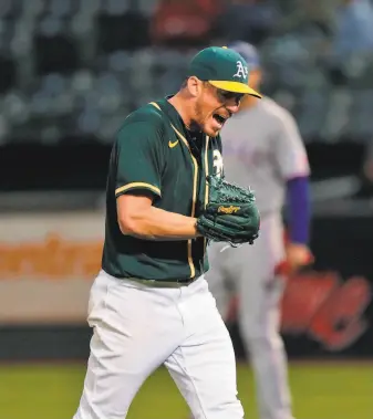  ?? Carlos Avila Gonzalez / The Chronicle ?? Chris Bassitt reacts to getting out of a tight situation with runners on the corners in the sixth inning. He threw seven scoreless innings, scattering three hits and striking out seven.