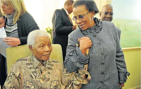  ?? Picture: ELMOND JIYANE ?? HANDS-ON: Nelson Mandela shares a moment with IEC chairwoman Brigalia Bam before casting his special vote in the 2011 local elections