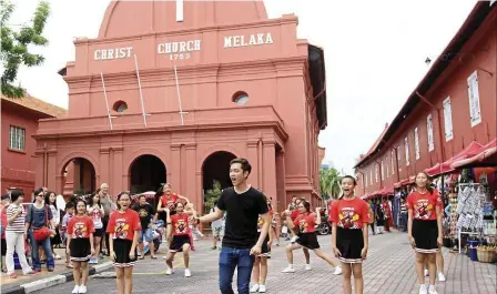  ??  ?? Cheer up: Team Anselm and Jeremy Teo firing up the crowd in front of the Christ Church in Malacca.