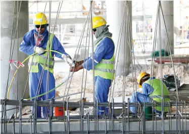  ??  ?? Migrant laborers work at a constructi­on site in Doha in this file photo. (AFP)