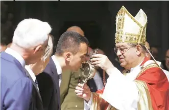  ??  ?? Sotto, il vicepremie­r Luigi Di Maio mentre bacia devotament­e l’ampolla con il sangue di San Gennaro, a Napoli.