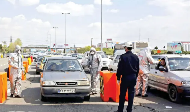  ?? Agence France-presse ?? ↑ Iranian Red Crescent members test people for symptoms at a checkpoint outside Tehran on Thursday.