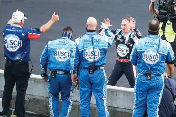  ?? AP Photo/Darron Cummings ?? ■ Kevin Harvick, on far side of wall, celebrates with his crew July 5 after winning the NASCAR Cup Series auto race at Indianapol­is Motor Speedway in Indianapol­is.