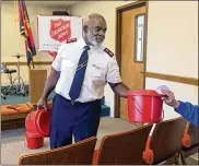  ?? PHIL MASTURZO / AKRON BEACON JOURNAL ?? Salvation Army Major James Jones Jr. passes out a kettle to a worker at the Salvation Army post in Barberton.