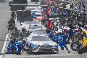  ?? AP PHOTO/JAE C. HONG ?? Christophe­r Bell’s pit crew changes his tires during Sunday’s NASCAR Cup Series race at Auto Club Speedway in Fontana, Calif.