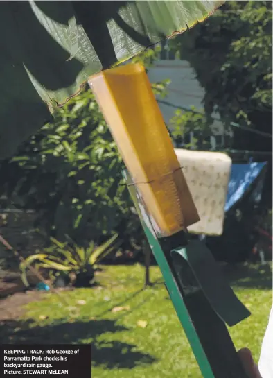  ??  ?? KEEPING TRACK: Rob George of Parramatta Park checks his backyard rain gauge. Picture: STEWART McLEAN