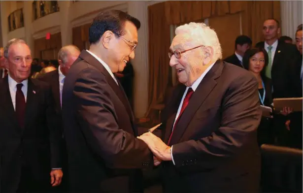  ?? PROVIDED TO CHINA DAILY ?? Premier Li Keqiang greets former secretary of state Henry Kissinger at the Waldorf Astoria New York hotel on Tuesday as former New York mayor Michael Bloomberg looks on.