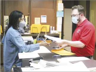  ?? Brodie Johnson • Times-Herald ?? The filing period for the May 24 Preferenti­al Primary Election began at noon today across the state. Candidates for county positions, such as judge, sheriff and collector, county clerk, circuit clerk, treasurer and assessor, as well as justices of the peace and constables, began filing paperwork today with St. Francis County Clerk Brandi McCoy. All positions on the Forrest City School Board and two seats on the Palestine-Wheatley School Board will also be on the May ballot. The filing period ends at noon Tuesday, March 1. SFC Chief Deputy Clerk Alan Smith, right, files paperwork with McCoy as a candidate for the SFC Circuit Clerk position.