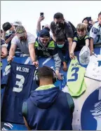  ?? The Associated Press ?? Seattle Seahawks quarterbac­k Russell Wilson signs autographs before a game against the Los Angeles Chargers in Seattle on Aug. 28.