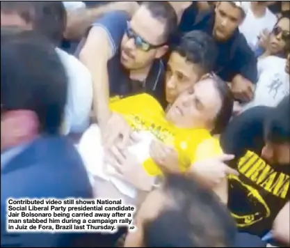  ?? AP ?? Contribute­d video still shows National Social Liberal Party presidenti­al candidate Jair Bolsonaro being carried away after a man stabbed him during a campaign rally in Juiz de Fora, Brazil last Thursday.