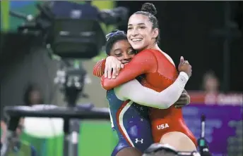  ?? Doug Mills/The New York Times ?? Americans Simone Biles and Aly Raisman embrace after the final in which Biles won gold and Raisman won silver.