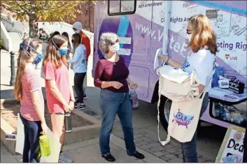  ?? Doug Walker ?? Leah Bartleson (from left), her sister Emily Bartleson and mother Tina Bartleson get ready to sign the vote bus prior to the Women’s March to the Polls in Rome Saturday.