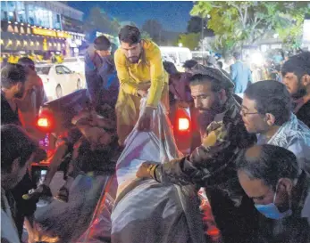  ?? FOTO: WAKIL KOHSAR/AFP ?? Freiwillig­e Helfer bringen Opfer der Anschläge in ein Krankenhau­s in Kabul.