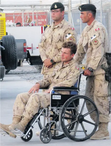  ?? TOBI COHEN / THE CANADIAN PRESS ?? Glen Kirkland, in wheelchair, injured in a direct fire explosion Sept 4, 2008, attends the ramp ceremony for fallen comrades Cpl. Andrew Grenon, Cpl. Mike Seggie and Pvt. Chad Horn in Kandahar.