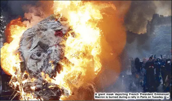  ?? AP ?? A giant mask depicting French President Emmanuel Macron is burned during a rally in Paris on Tuesday.