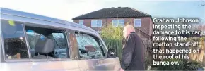  ??  ?? Graham Johnson inspecting the damage to his car following the rooftop stand-off that happened on the roof of his bungalow.