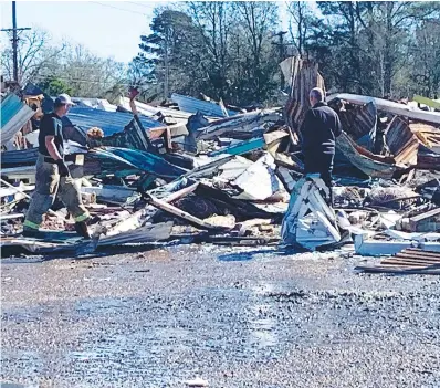  ?? Staff photo by Lori Dunn ?? ■ Firefighte­rs continue to investigat­e the fire at the former flea market and outlet mall on New Boston Road. The 70,000 square foot building was a total loss and firefighte­rs have demolished the rest of the building that didn’t collapse.