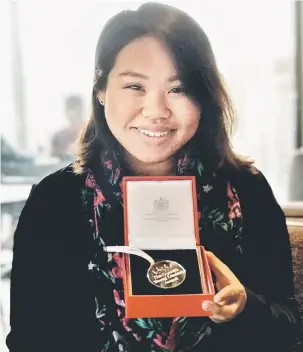  ?? — Gambar Bernama ?? MASIH MUDA: Heidy menunjukka­n pingat yang diterimany­a di London.