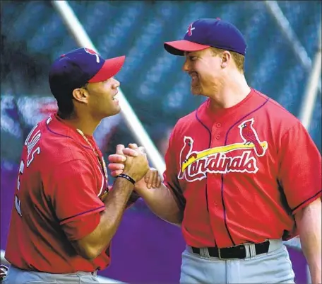  ?? Scott Rovak AFP via Getty Images ?? ALBERT PUJOLS, left, and Mark McGwire share a moment during workouts before the NL Division Series in 2001, Pujols’ rookie season. “A lot of guys have a good couple of months, maybe a good year, but they can’t repeat it,” McGwire said. “Look what Albert did.”