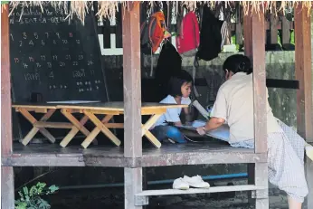  ??  ?? TOUCH WOOD: A group of teenagers are engrossed in a handiwork project. The school views child developmen­t in three distinct seven-year stages: the early years, the time before puberty and adolescenc­e.