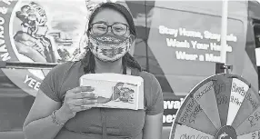  ?? THE NAVAJO & HOPI FAMILIES COVID- 19 RELIEF FUND VIA AP ?? Natasha Goldtooth shows off a gift certificate she won via a vaccine prize wheel in Window Rock, Ariz.