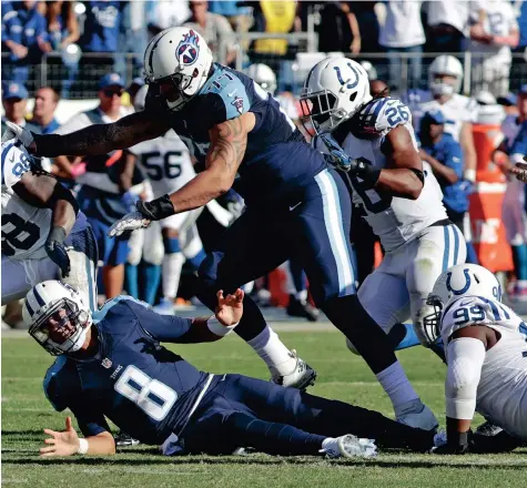  ?? THE ASSOCIATED PRESS ?? Indianapol­is Colts outside linebacker Robert Mathis (98) recovers a fumble after Colts defensive tackle T.Y. McGill (99) stripped the ball away from Tennessee Titans quarterbac­k Marcus Mariota.