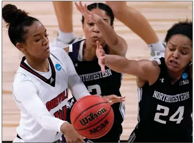  ?? (AP/Charlie Riedel) ?? Louisville’s Kianna Smith (left) throws a pass Wednesday while being guarded by Northweste­rn’s Jordan Hamilton (24) and Sydney Wood during the second half of the Cardinals’ 62-53 victory over the Wildcats in San Antonio. Smith scored 16 points as Louisville rallied from an 18-point deficit to advance to the Sweet 16.