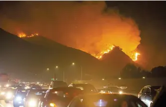  ?? Xinhua-Yonhap ?? Fire is seen near Getty Center in Los Angeles, Monday. Thousands of residents were forced to evacuate their homes after a fast-moving wildfire erupted near the famous Getty Center.