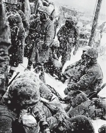  ?? United States Marine Corps ?? A group of Marines fighting their way from the communist encircleme­nt at Chosin to Hungnam, Korea, take a rest in the snow somewhere on the route on Dec. 1950 during the Korean War.