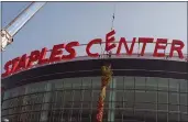  ?? XERRO RYAN COVARRUBIA­S — THE ASSOCIATED PRESS, FILE ?? Constructi­on workers put the finishing touches on the Staples Center sign outside the arena in Los Angeles on Sept. 16, 1999.