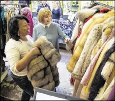  ?? STEVE SCHAEFER / CONTRIBUTE­D ?? Lynette Gamble (left) and Peggy Newfield look over fur coats, some of which belonged to Atlanta business executive Diane McIver, at the Ahlers & Ogletree auction house in Atlanta on Saturday.