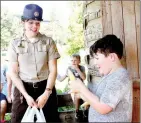  ??  ?? Laura Jennings, park interprete­r for Prairie Grove Battlefiel­d State Park, visits with one of the kids at a new day camp held in the summer. This was the Pioneer Life Day Camp.