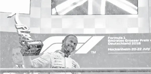  ?? ASSOCIATED PRESS ?? Mercedes driver Lewis Hamilton of Britain celebrates on the podium after winning the German Formula One Grand Prix at the Hockenheim­ring racetrack in Hockenheim, Germany.